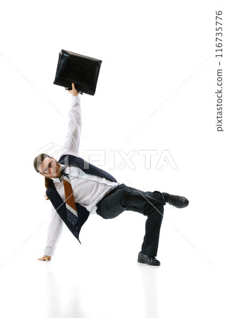 Breakdancer in business attire performs one-handed freeze while holding briefcase against white studio background. Flexibility. 116735776