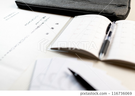 A handwritten resignation letter, a new schedule book, and a farewell gift envelope and brush pen 116736069