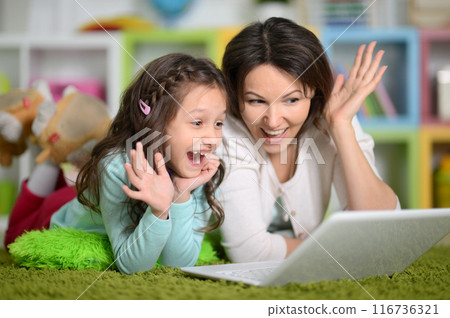 Happy laughing mother and little cute daughter using laptop 116736321