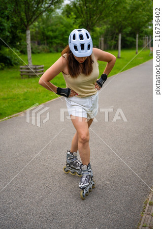 Roller skater woman in park rollerblading on inline skates. Outdoor activities. Summer roller skating. 116736402
