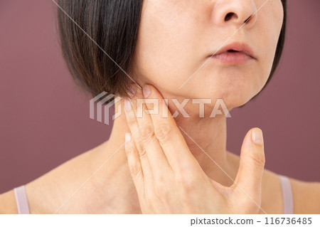 Middle-aged woman doing lymphatic massage around the neck Middle-aged woman doing lymphatic massage around the neck 116736485