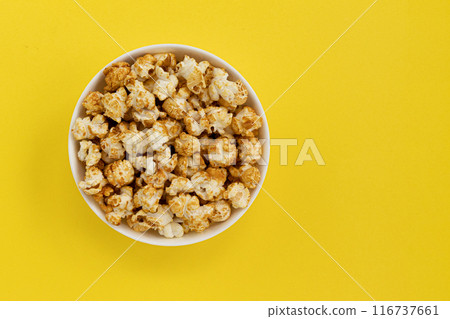 caramel popcorn in bowl on yellow close up, sweet snacks 116737661