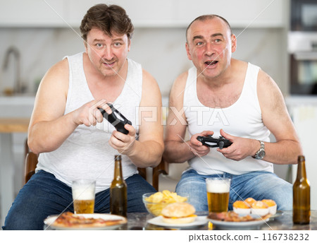 Two adult men playing video game console Two adult men playing video game console 116738232