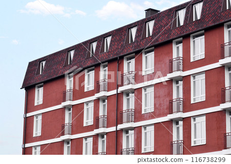 building a new house , the brown facade of the building with balconies against blue sky 116738299
