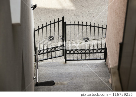 Grey steps in city and old metal gate. Detail of old staircase. Abstract wrought iron gate. Background Grey steps in city and old metal gate. Detail of old staircase. Abstract wrought iron gate. Background 116739235