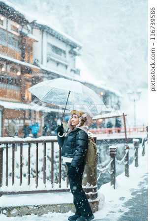 Woman tourist Visiting Ginzan Onsen in Yamagata, happy Traveler sightseeing Japanese Onsen village with Snow in winter season. landmark and popular for attraction in Japan. Travel and Vacation concept Woman tourist Visiting Ginzan Onsen in Yamagata, happy Traveler sightseeing Japanese Onsen village with Snow in winter season. landmark and popular for attraction in Japan. Travel and Vacation concept 116739586