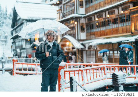man tourist Visiting Ginzan Onsen in Yamagata, happy Traveler sightseeing Japanese Onsen village with Snow in winter season. landmark and popular for attraction in Japan. Travel and Vacation concept man tourist Visiting Ginzan Onsen in Yamagata, happy Traveler sightseeing Japanese Onsen village with Snow in winter season. landmark and popular for attraction in Japan. Travel and Vacation concept 116739621