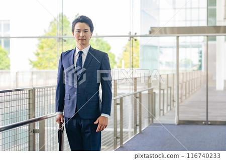 Businessman standing in lobby Businessman standing in lobby 116740233