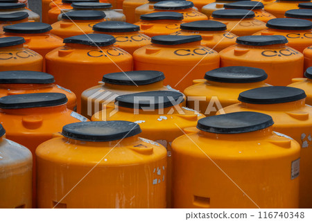 Orange cylindrical containers are placed close together. Orange cylindrical containers are placed close together. 116740348