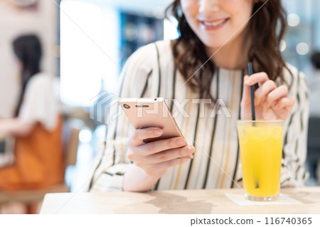 咖啡館裡看著智慧型手機的中年婦女攝影合作：Creadisce（丸善湯堂株式會社） 116740365