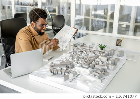 Expert man architect drawing blueprints in his workplace 116741077