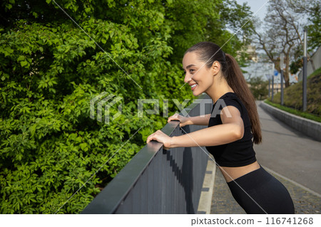 Fitness woman doing sport exercises enjoying outdoor workout in park 116741268