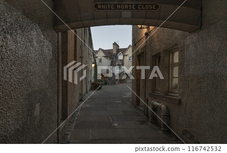 Perspective view of the alleyways into the famous "White Horse Close" on Royal Mile in the Old Town of Edinburgh city. Perspective view of the alleyways into the famous "White Horse Close" on Royal Mile in the Old Town of Edinburgh city. 116742532