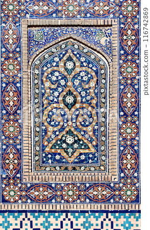 Vertical background with detail of ancient mosaic walls with floral and geometric ornament. Traditional tile decoration on wall, Bukhara, Uzbekistan 116742869