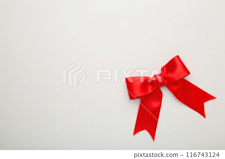 Shiny red satin bow on grey background. 116743124