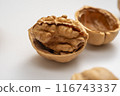 Close-up of Walnuts, Halved, in Shells on a White Background 116743337