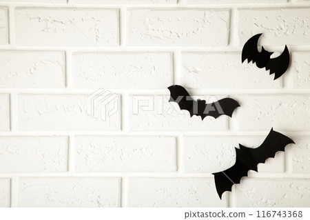 Halloween, decoration and scary concept - black paper bats flying over white background Halloween, decoration and scary concept - black paper bats flying over white background 116743368