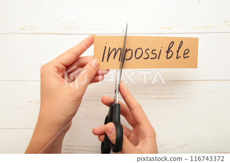 Impossible Is Possible Concept. card with the text impossible, cutting the word im so it written possible. 116743372