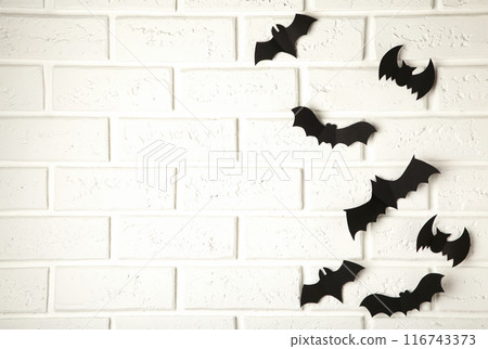 Halloween, decoration and scary concept - black paper bats flying over white background 116743373