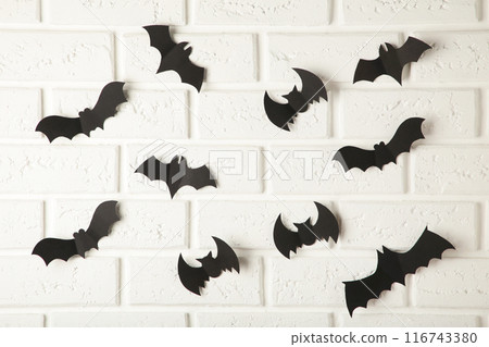 Halloween, decoration and scary concept - black paper bats flying over white background 116743380