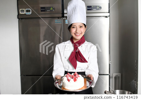 Asian female pastry chef holding cake 116743419