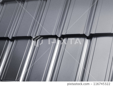 Close-up view lightweight galvanised steel roofing sheet. Modular tile effect roof panel. Traditional metal shingle tiles. Popular profiled metallic pantile mimic clay or concrete slate Close-up view lightweight galvanised steel roofing sheet. Modular tile effect roof panel. Traditional metal shingle tiles. Popular profiled metallic pantile mimic clay or concrete slate 116745322