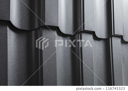 Close-up view lightweight galvanised steel roofing sheet. Modular tile effect roof panel. Traditional metal shingle tiles. Popular profiled metallic pantile mimic clay or concrete slate 116745323