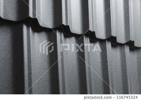 Close-up view lightweight galvanised steel roofing sheet. Modular tile effect roof panel. Traditional metal shingle tiles. Popular profiled metallic pantile mimic clay or concrete slate Close-up view lightweight galvanised steel roofing sheet. Modular tile effect roof panel. Traditional metal shingle tiles. Popular profiled metallic pantile mimic clay or concrete slate 116745324