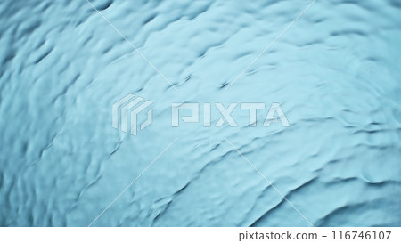 Freeze motion of splashing water surface on light blue background Freeze motion of splashing water surface on light blue background 116746107