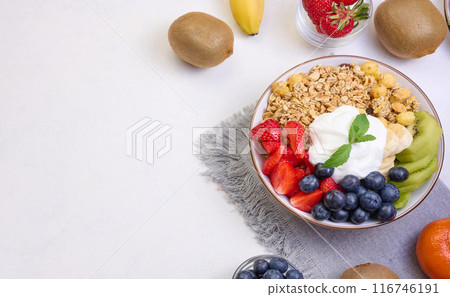Granola with strawberries, kiwi, banana and blueberries in a round plate Granola with strawberries, kiwi, banana and blueberries in a round plate 116746191