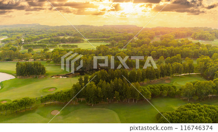 Golf course at sunset. Scenic panoramic aerial view of golf course at sunset with beautiful sky. Drone view Golf course at sunset. Scenic panoramic aerial view of golf course at sunset with beautiful sky. Drone view 116746374