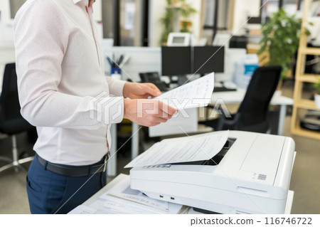 Corporate Efficiency: Businessman Operating Multifunction Printer Corporate Efficiency: Businessman Operating Multifunction Printer 116746722
