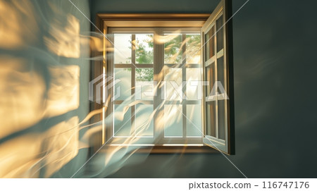 Sunlight streaming through an open window with flowing curtains, serene morning interior concept 116747176