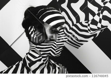 A woman's face is painted with black and white stripes A woman's face is painted with black and white stripes 116748045