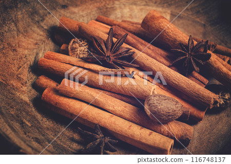 cinnamon sticks, with nutmeg and anise star, in a wooden plate, top view, no people, 116748137
