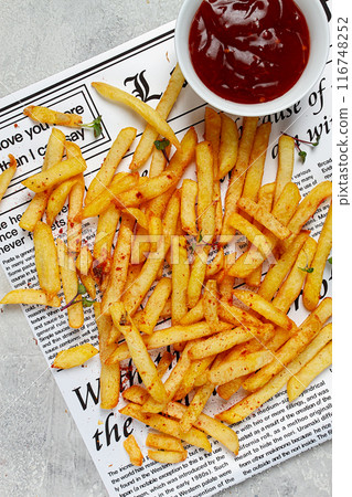 fried French fries, scattered on a newspaper, with red sauce, top view, no people, 116748252
