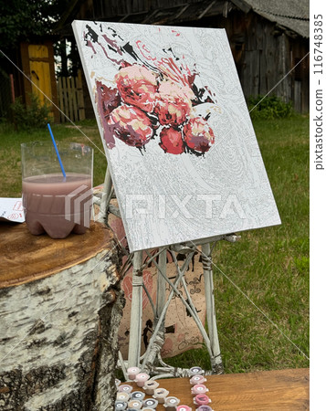 Rication canvas by numbers. Stands on the stand. Near the paint in numbered jars and a can of water. 116748385