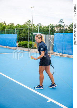 Professional female tennis player serving the tennis ball during playing on outside court 116749062