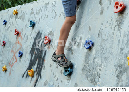 photo of the young boys leg climbing on the climbing wall in the park photo of the young boys leg climbing on the climbing wall in the park 116749453