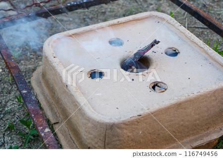 Charcoal starter box igniting with a smoke Charcoal starter box igniting with a smoke 116749456