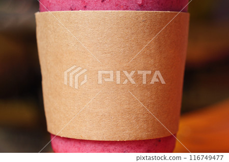 Mockup of a pink beverage in a clear plastic cup wrapped in a brown paper sleeve Mockup of a pink beverage in a clear plastic cup wrapped in a brown paper sleeve 116749477