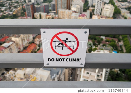 Do not climb sign on rooftop railing Do not climb sign on rooftop railing 116749544