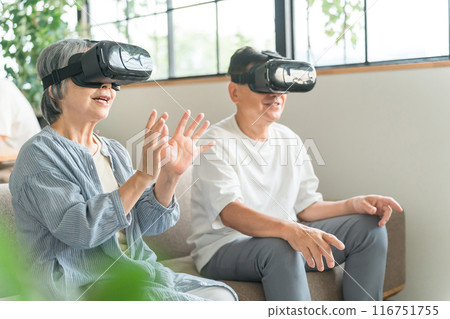 A senior couple wearing VR goggles experiencing the virtual reality metaverse A senior couple wearing VR goggles experiencing the virtual reality metaverse 116751755