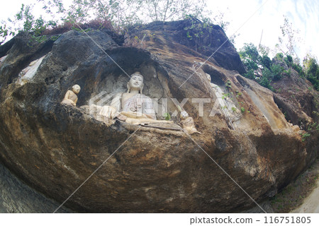 Akauk Taung has a Buddha image carved in sandstone on the Akauk Mountain cliff along the Ayeyavadee River near Htonbo village. Magway Region.Myanmar. 116751805