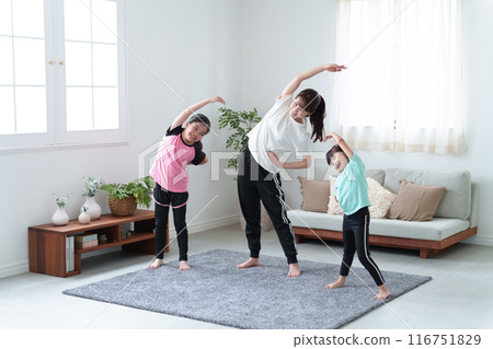 Parents and children stretching in the living room 116751829