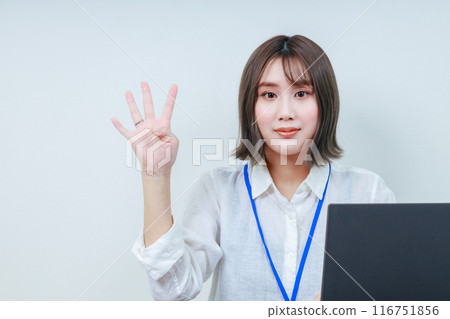 A young female staff member making a number four with her right hand A young female staff member making a number four with her right hand 116751856