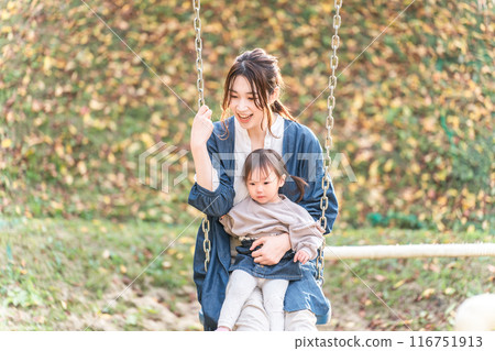 父母，媽媽朋友，孩子（嬰兒，野餐，育兒，育兒）在秋季公園鞦韆上玩耍 116751913