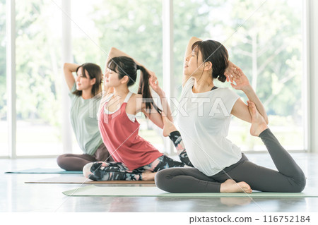 在瑜伽館和瑜伽課（體育館）中練習瑜伽和普拉提的女性 116752184