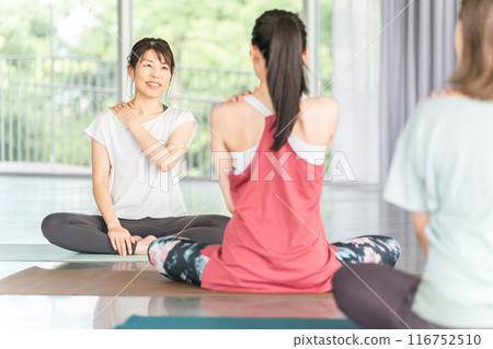 A female yoga teacher/instructor teaching yoga, neck care, and shoulder stiffness relief in a yoga class/Pilates class A female yoga teacher/instructor teaching yoga, neck care, and shoulder stiffness relief in a yoga class/Pilates class 116752510