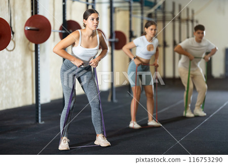Group CrossFit classes - people doing sports with elastic bands Group CrossFit classes - people doing sports with elastic bands 116753290